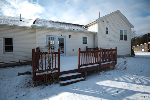 snow covered house with a wooden deck