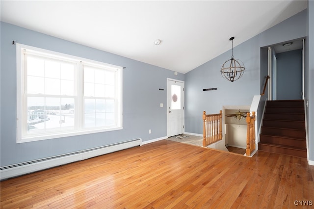 entrance foyer featuring an inviting chandelier, a baseboard heating unit, vaulted ceiling, baseboards, and hardwood / wood-style flooring