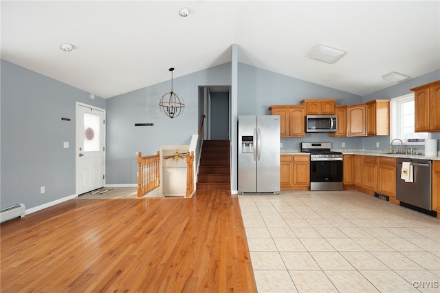 kitchen featuring light countertops, an inviting chandelier, appliances with stainless steel finishes, vaulted ceiling, and baseboards