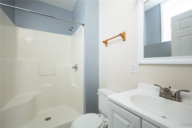 bathroom featuring vanity, walk in shower, and toilet