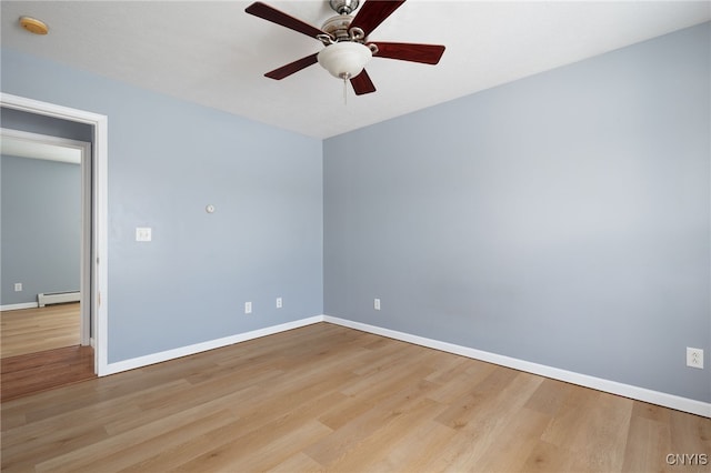 unfurnished room featuring a baseboard heating unit, ceiling fan, wood finished floors, and baseboards