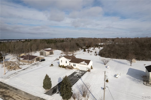 snowy aerial view with a wooded view