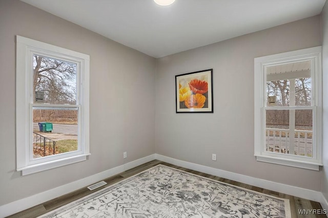 unfurnished room featuring hardwood / wood-style flooring and plenty of natural light