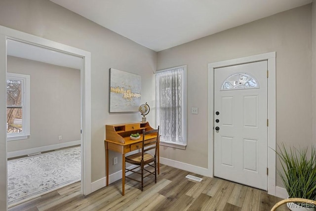 foyer entrance featuring light wood-type flooring and plenty of natural light