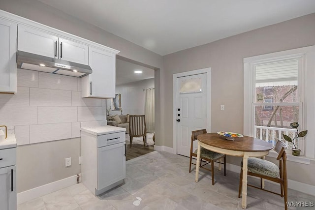 kitchen featuring tasteful backsplash and white cabinetry