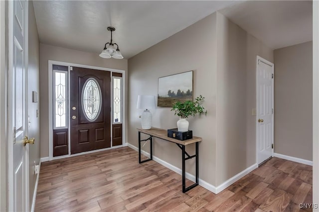 foyer featuring light hardwood / wood-style floors and an inviting chandelier