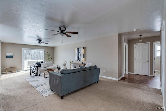 living room featuring ceiling fan, light colored carpet, and a wealth of natural light