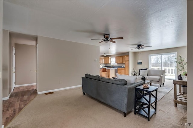 carpeted living room with ceiling fan