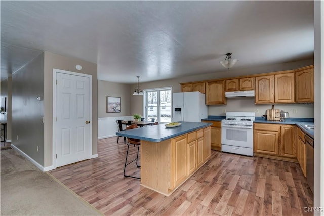 kitchen featuring a center island, pendant lighting, white appliances, and light hardwood / wood-style flooring