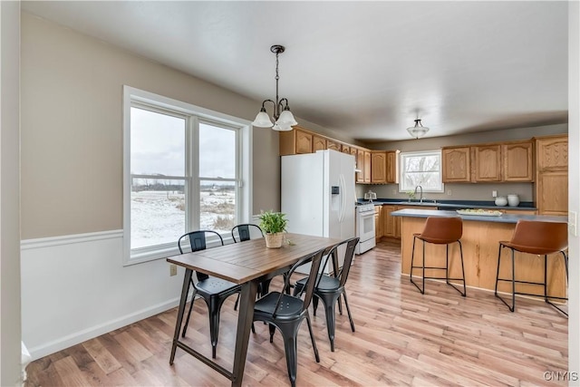 dining room featuring light hardwood / wood-style flooring, an inviting chandelier, and sink