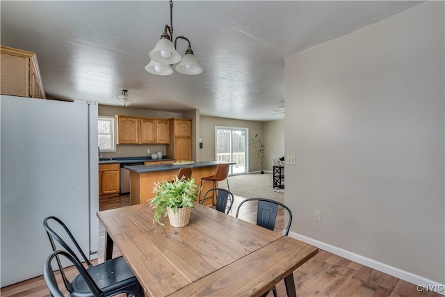 dining space with a chandelier and light hardwood / wood-style flooring