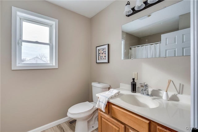 bathroom featuring hardwood / wood-style flooring, vanity, and toilet