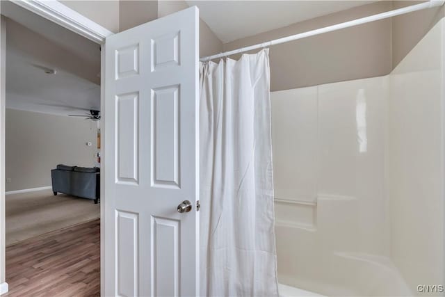 bathroom featuring ceiling fan, hardwood / wood-style floors, and a shower with shower curtain