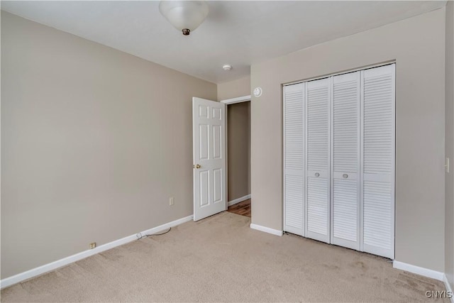 unfurnished bedroom with light carpet and a closet