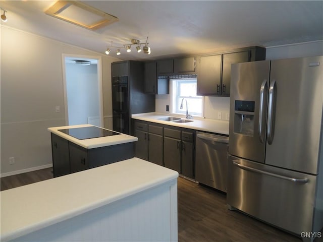 kitchen featuring appliances with stainless steel finishes, dark wood-type flooring, sink, and a kitchen island