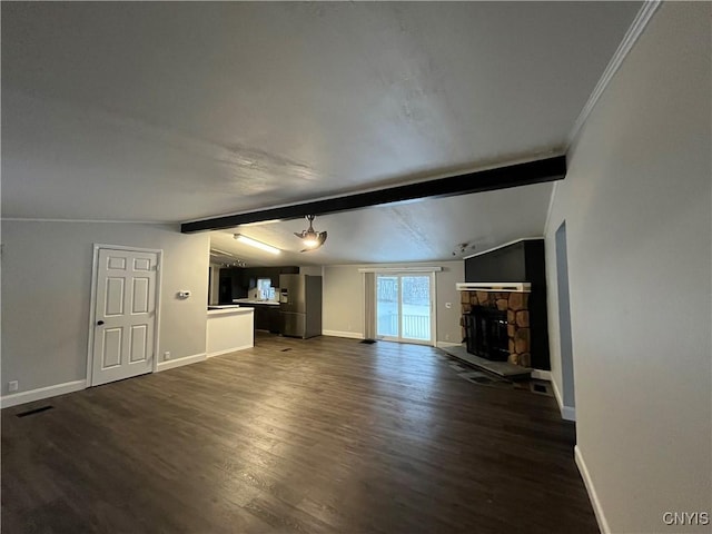 unfurnished living room with dark hardwood / wood-style floors, vaulted ceiling with beams, crown molding, and a stone fireplace