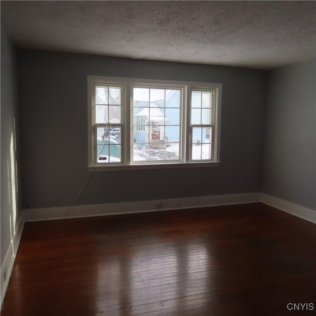 unfurnished room featuring dark hardwood / wood-style floors and a textured ceiling