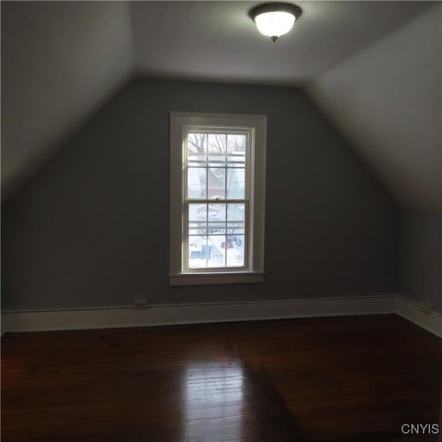 bonus room with dark wood-type flooring and lofted ceiling