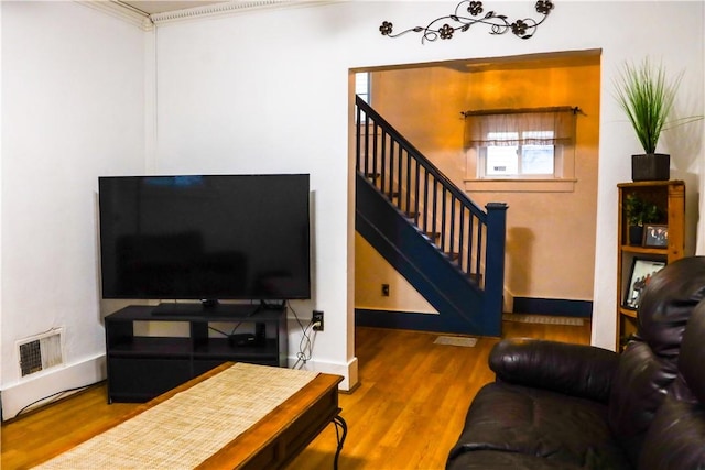 living room with hardwood / wood-style flooring and ornamental molding