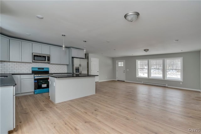 kitchen featuring stainless steel appliances, a kitchen island, hanging light fixtures, and a baseboard radiator