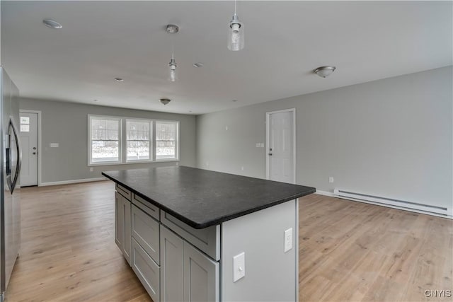 kitchen featuring light hardwood / wood-style floors, a kitchen island, a baseboard heating unit, and gray cabinetry