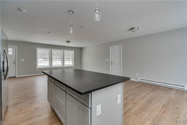 6661 Pine Grove Rd, Watson, NY 13343 - kitchen with open floor plan, a baseboard radiator, dark countertops, light wood-type flooring, and a kitchen island