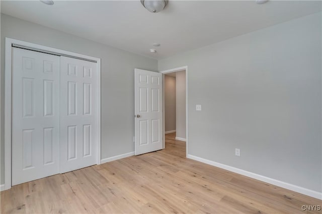 unfurnished bedroom with a closet and light hardwood / wood-style flooring