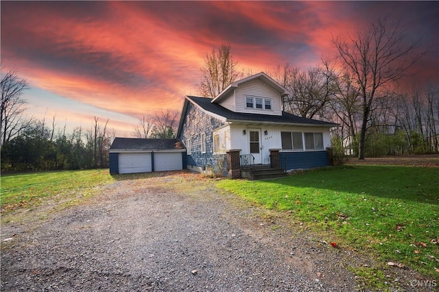 view of front of house featuring a yard, an outbuilding, and a garage