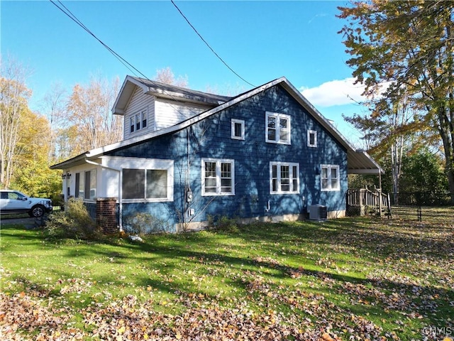 view of property exterior with cooling unit and a yard