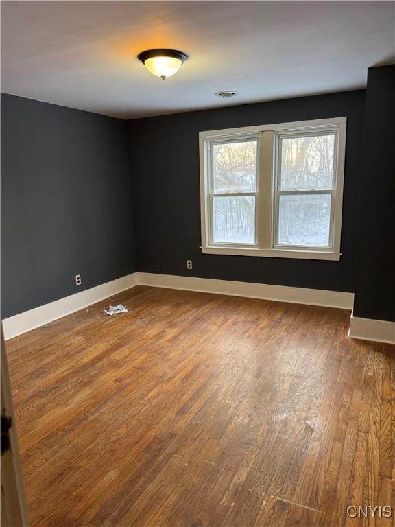 unfurnished room with hardwood / wood-style flooring