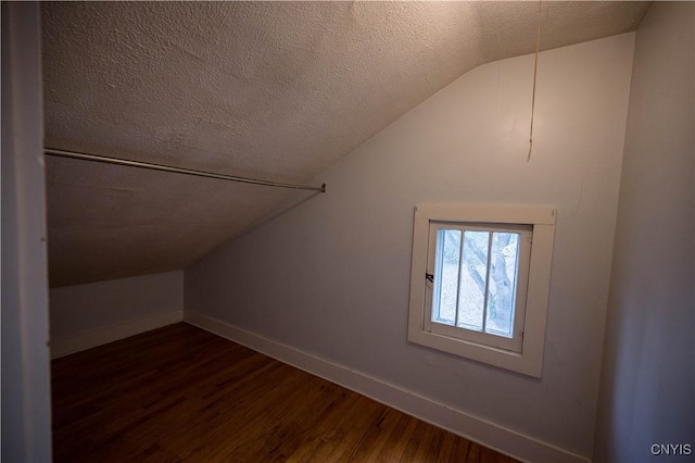 bonus room featuring a textured ceiling, dark hardwood / wood-style flooring, and lofted ceiling