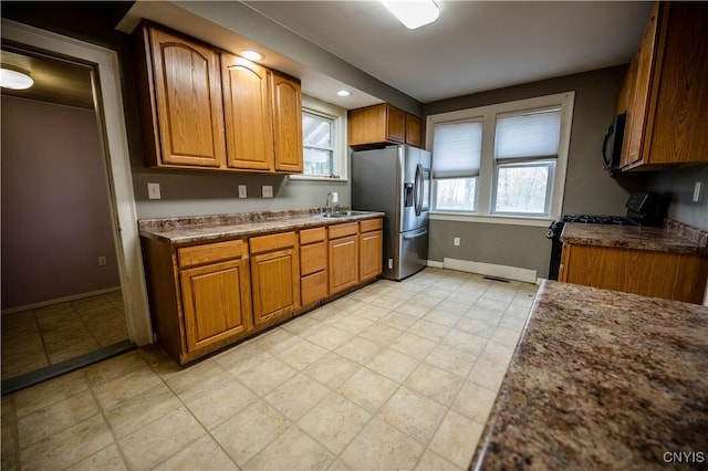 kitchen with stainless steel fridge, black electric range oven, and sink