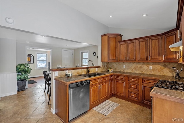 kitchen featuring a wealth of natural light, dishwasher, sink, vaulted ceiling, and a breakfast bar area