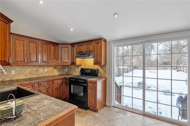 kitchen with decorative backsplash, black gas range, lofted ceiling, and sink