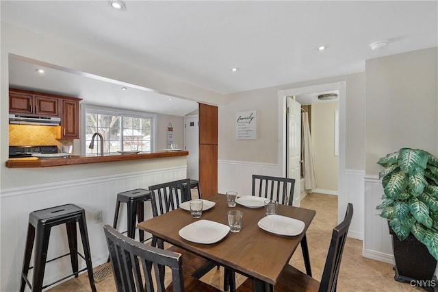 tiled dining room featuring sink