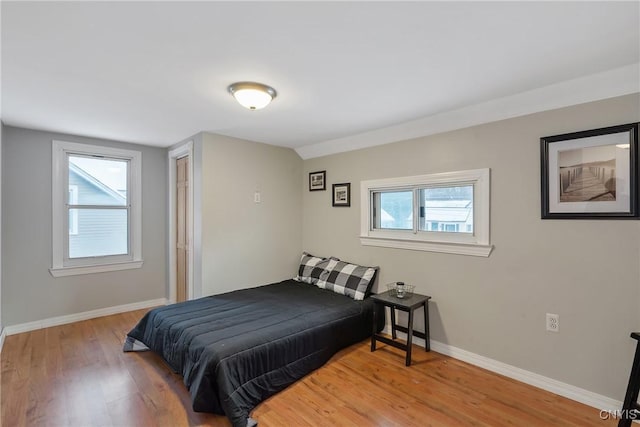 bedroom with multiple windows and wood-type flooring