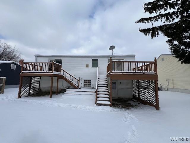 snow covered house featuring a deck