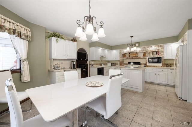 tiled dining area featuring sink and an inviting chandelier