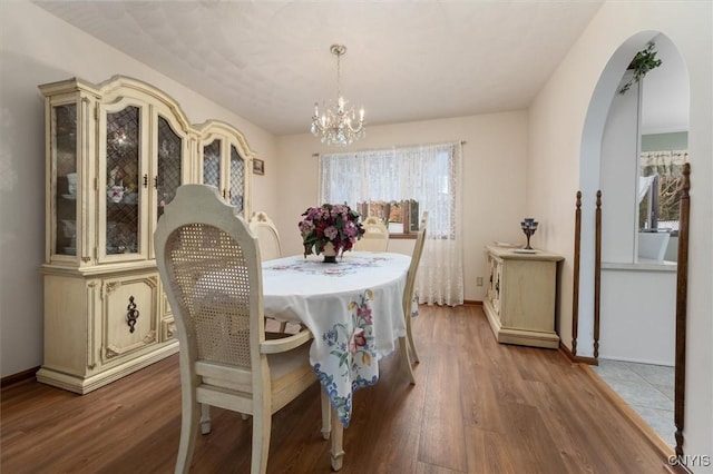 dining space featuring hardwood / wood-style flooring and a chandelier