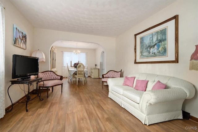 living room with light wood-type flooring and an inviting chandelier