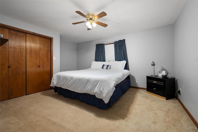 bedroom featuring ceiling fan, light carpet, and a closet