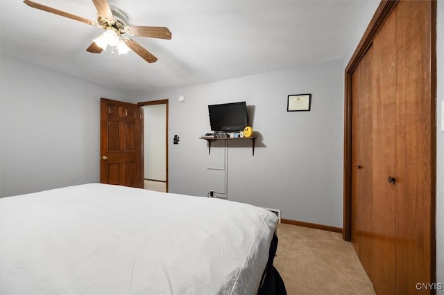 carpeted bedroom with ceiling fan and a closet