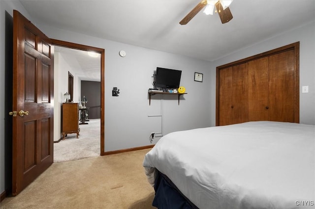 carpeted bedroom featuring ceiling fan and a closet