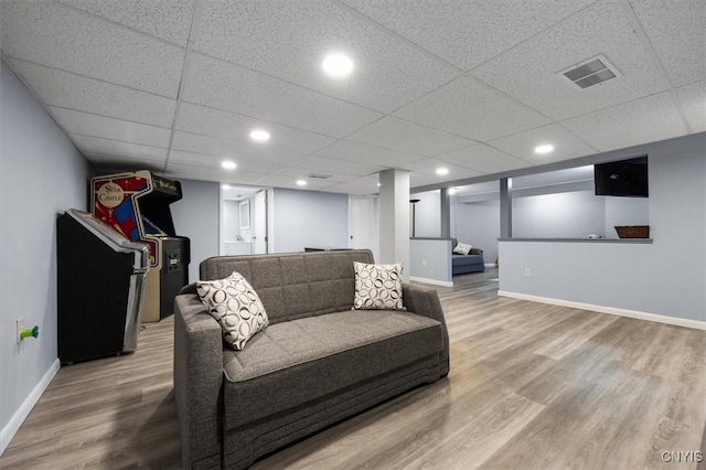 living room with hardwood / wood-style floors and a drop ceiling