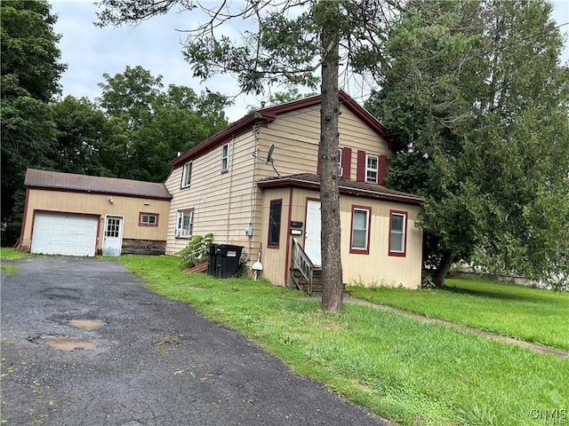 view of front of home featuring an outbuilding, a front yard, and a garage