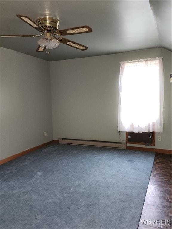 spare room with ceiling fan, a baseboard radiator, and vaulted ceiling