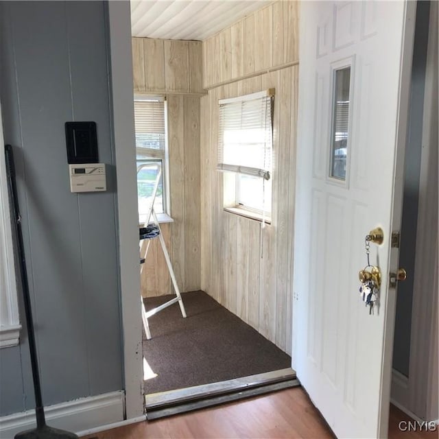 doorway featuring wood walls and dark hardwood / wood-style flooring