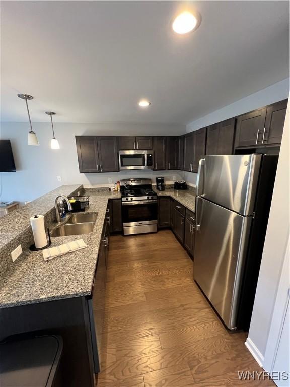 8977 Iroquois St, Evans, NY 14006 - kitchen featuring pendant lighting, sink, appliances with stainless steel finishes, light stone countertops, and kitchen peninsula