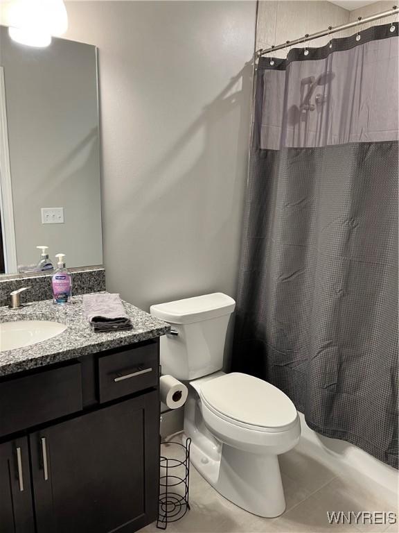 8977 Iroquois St, Evans, NY 14006 - bathroom with vanity, walk in shower, tile patterned floors, and toilet