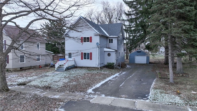 view of property with a garage and an outbuilding